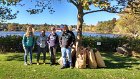 People Making a Difference® volunteers rested after collecting many bags full of autumn leaves and natural debris in brown paper bags and invasive plants in black plastic bags.