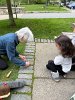 Olivia, 6-year-old FSPP member, watched Lally Stowell, Stewardship Team, demonstrate how to remove the grass growing between the cobblestones.
