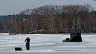 Chris set up his fishing pole and drilled a hole in the ice with his shanty set up behind him.