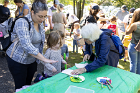 As the girl listened intently, Diana Maggini and her mother gave instructions for leaf printing.